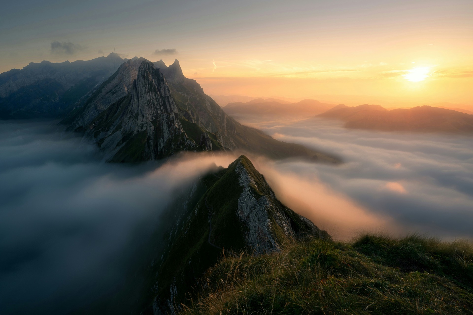 Alpine ridge above a sea of clouds at dusk